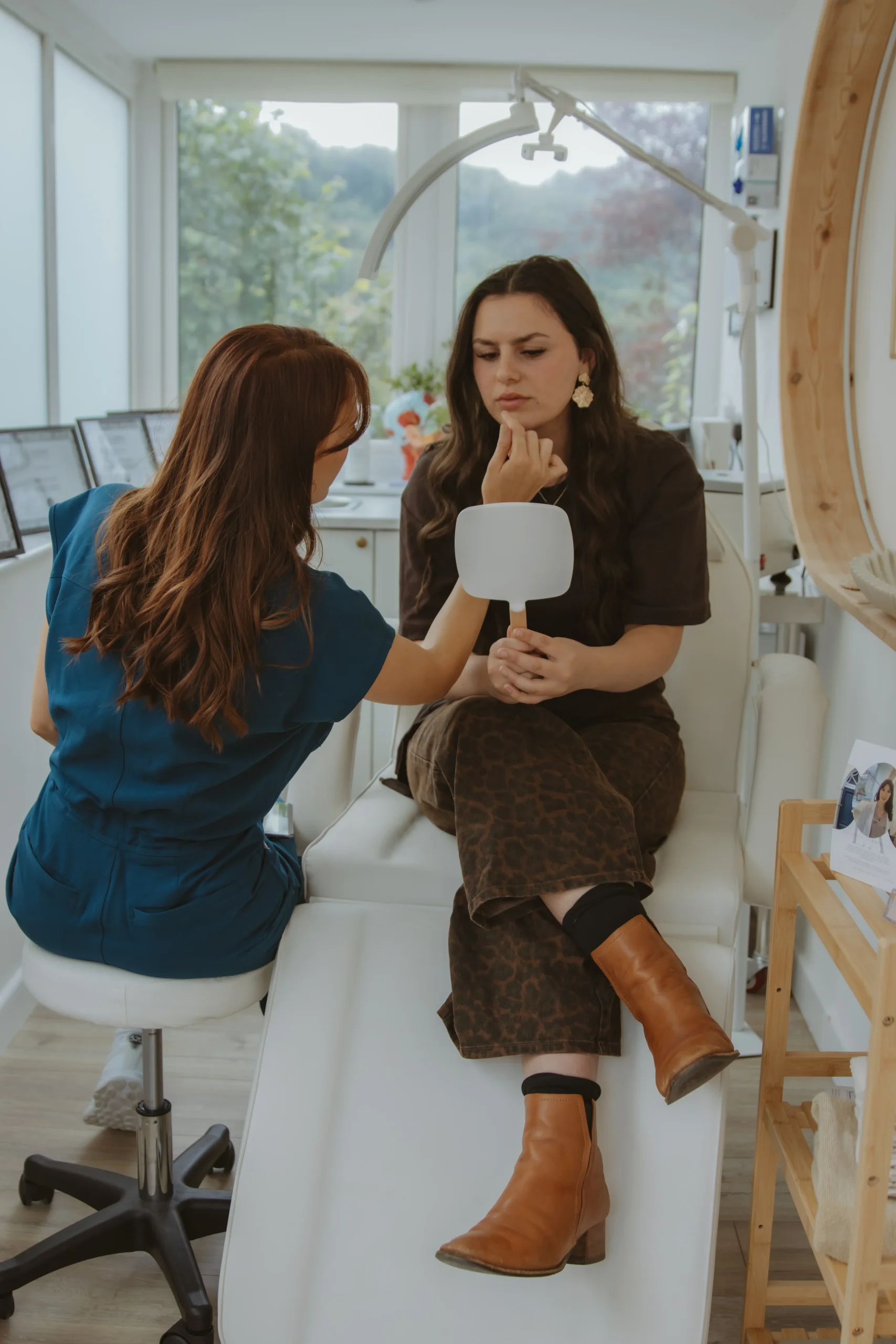 Jasmine assessing a client’s facial features using a hand mirror