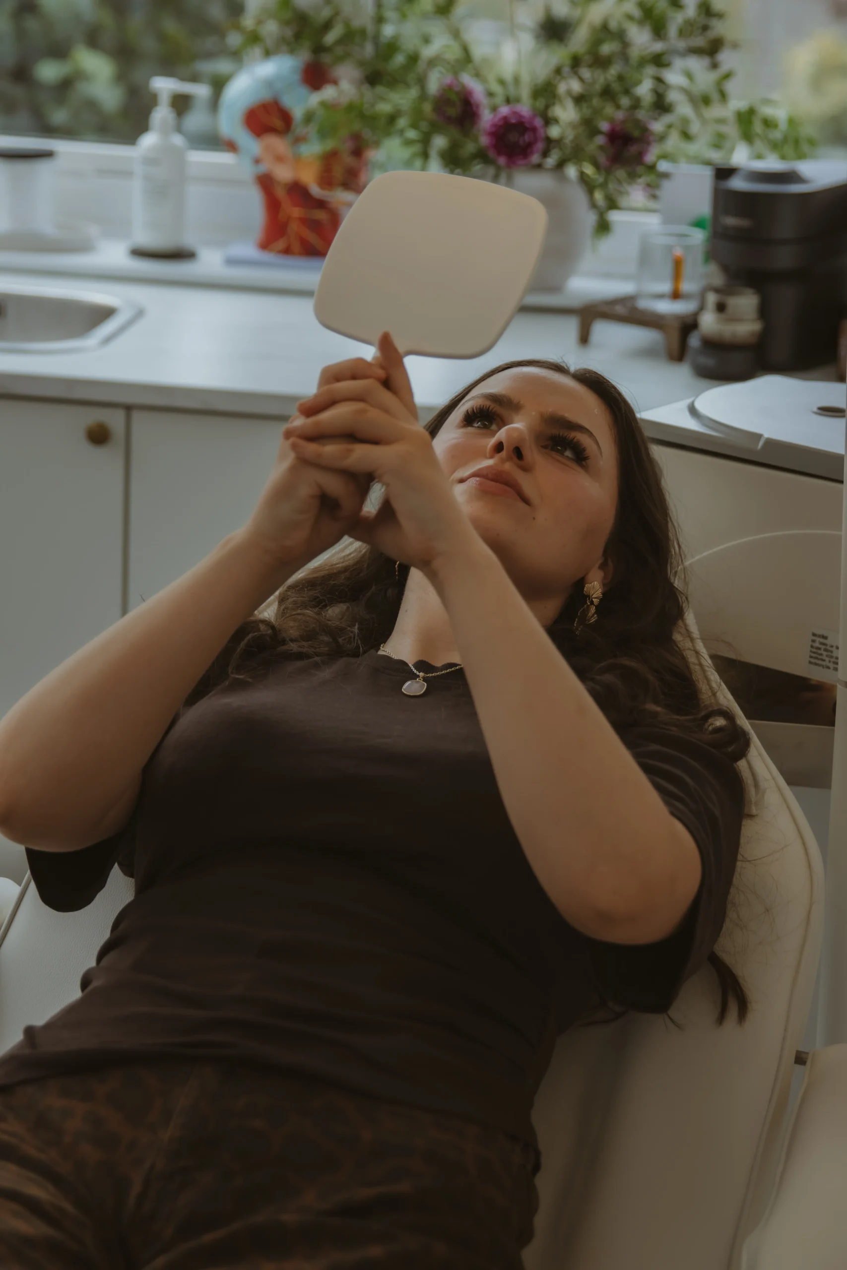 Client viewing her natural-looking results in a hand mirror